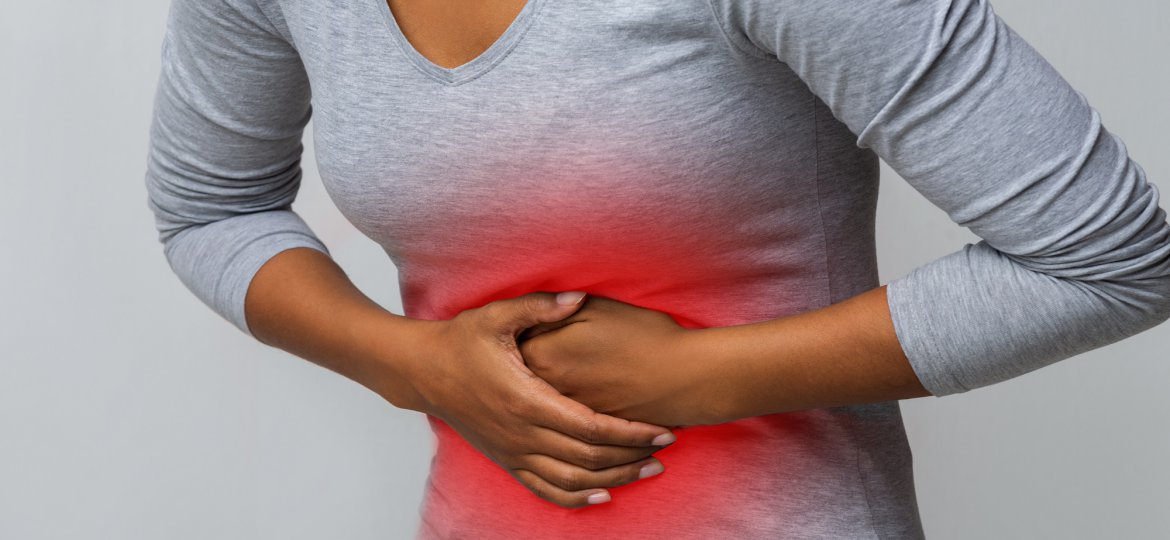 Woman with abdominal pain over grey background