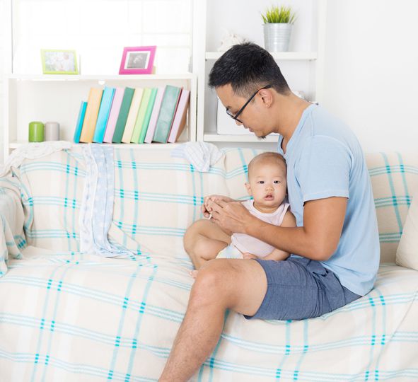 Tired father taking care baby at home.