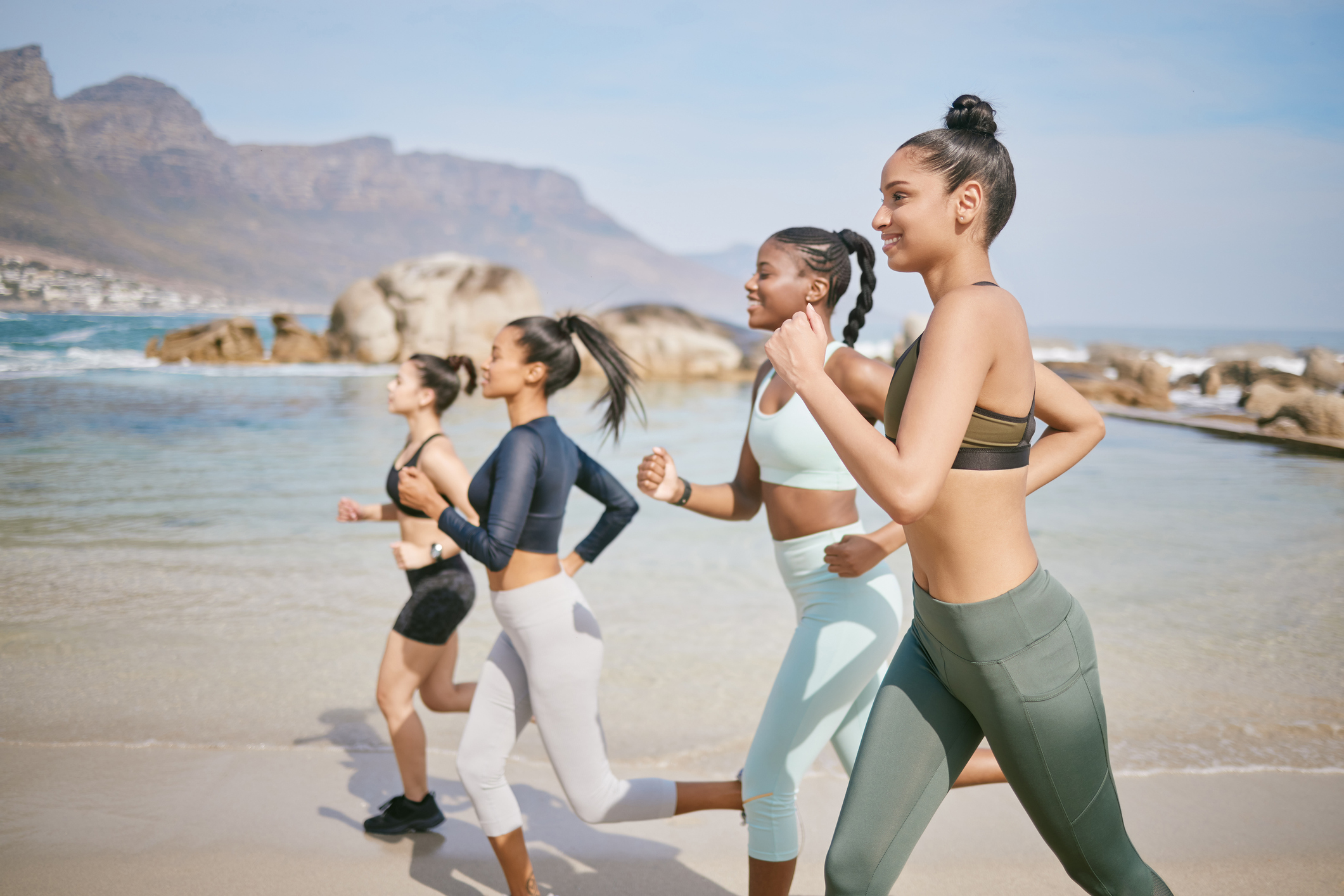 Shot of a group of women jogging together on the beach